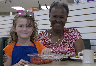 Emily Marie Abraham does a little direct tomato marketing with Gloria Smith at Rayfield's.